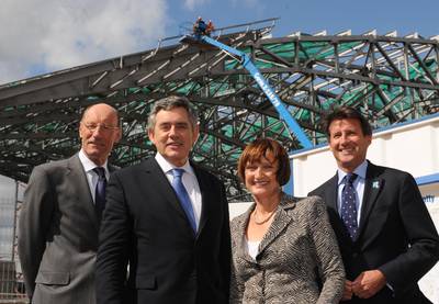 It's 2009 and British prime minister Gordon Brown visits the construction site with Olympics secretary Tessa Jowell, chairman of the London Organising Committee for the Olympic Games Lord Sebastian Coe, and chairman of the Olympic Delivery Authority John Armitt.