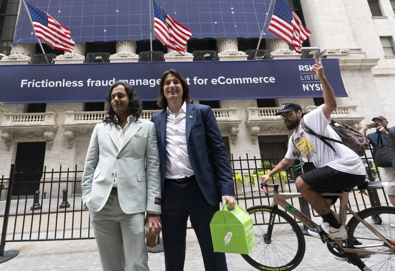 Baiju Bhatt, left, and Vladimir Tenev, co-founders of Robinhood, walk by the New York Stock Exchange following their company's IPO at Nasdaq, New York, last month. AP