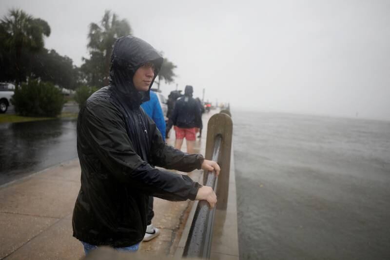 A local resident braces himself as he looks out at the Charleston Harbour while rain and wind from Hurricane Ian bear down on the city. Reuters