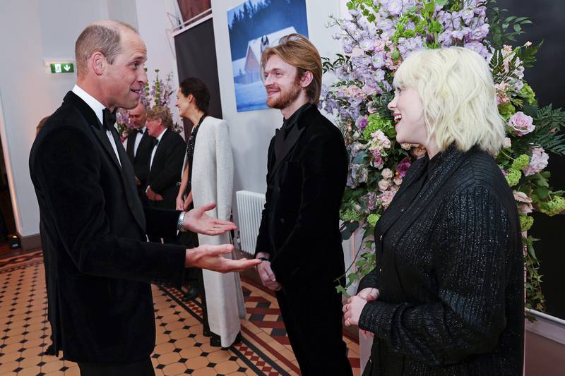 Prince William, left, speaks with performers Finneas O'Connell and Billie Eilish at the world premiere of 'No Time to Die' in London on September 28, 2021. AP