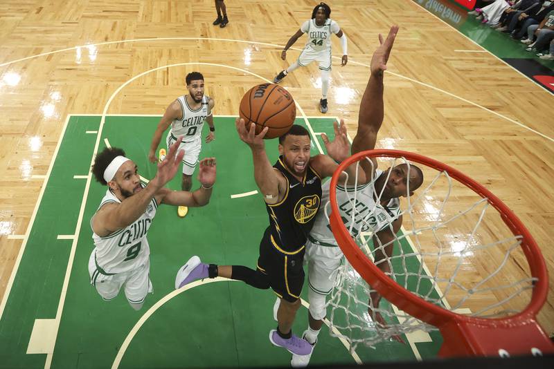 Golden State Warriors player Stephen Curry, centre, goes up for a shot against Al Horford of the Boston Celtics, right, and Derrick White during Game 4 of the NBA finals, in Boston. AP 