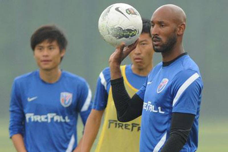 Shanghai Shenhua's French football player Nicolas Anelka poses with a Chinese immigration officer on his arrival at the Shanghai Pudong airport in China..