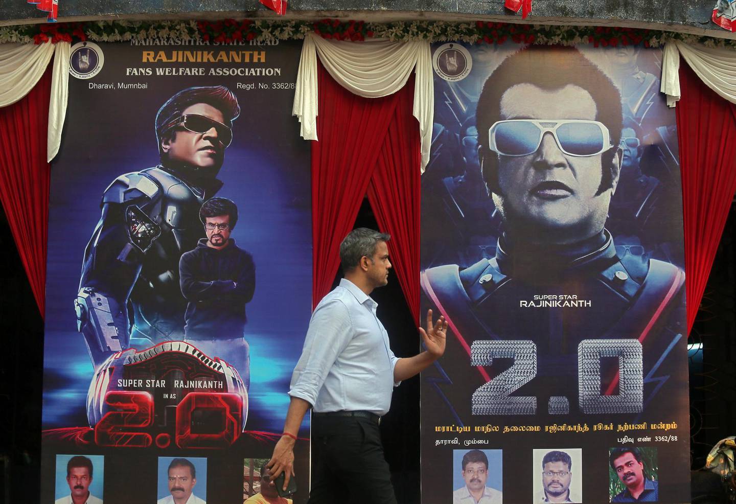 A man walks past a cinema decorated with posters of Tamil film star Rajinikanth's new movie "2.0" on the eve of its release, in Mumbai, India, November 28, 2018. REUTERS/Francis Mascarenhas