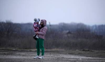 A woman who fled the conflict stands with her child at a refugee centre in Palanca, Moldova. EPA