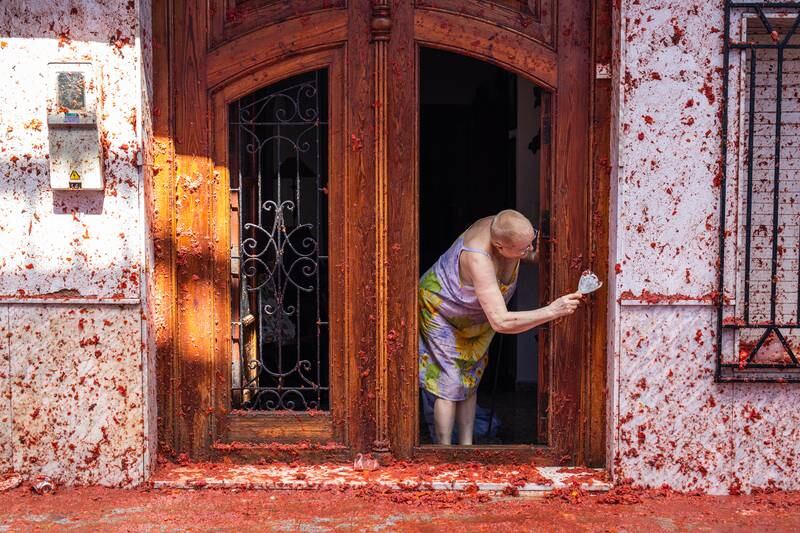 Carmen Sez, 71, cleans tomato remains from the front door of her house after the Tomatina festival in Bunol, Spain. Getty Images