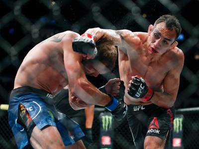FILE - In this June 8, 2019, file photo, Tony Ferguson, right, punches Donald Cerrone, left, during their lightweight mixed martial arts bout at UFC 238 in Chicago. The UFC says Ferguson will fight Justin Gaethje for the interim lightweight title in the main event of UFC 249 on April 18, 2020. The mixed martial arts promotion announced the matchup Monday, April 6, 2020. Gaethje replaces lightweight champ Khabib Nurmagomedov, who is apparently unable to leave Russia during the coronavirus pandemic. (AP Photo/Kamil Krzaczynski, File)