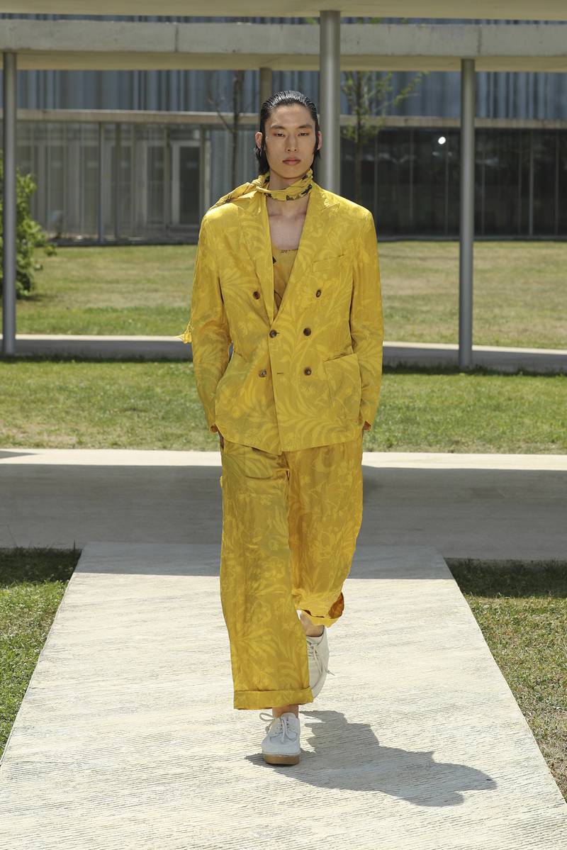 A loose, boxy suit in mustard yellow is covered in lemon-toned flowers on the runway at the Etro spring/summer 2023 menswear show.