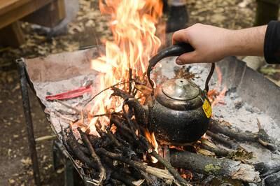 A kettle is boiled over the campfire in Fneidek forest. Photo: Finbar Anderson /The National