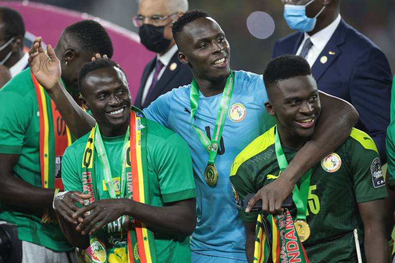 Edouard Mendy, centre, celebrates Senegal's Africa Cup of Nations triumph with Sadio Mane and Bamba Dieng. AFP