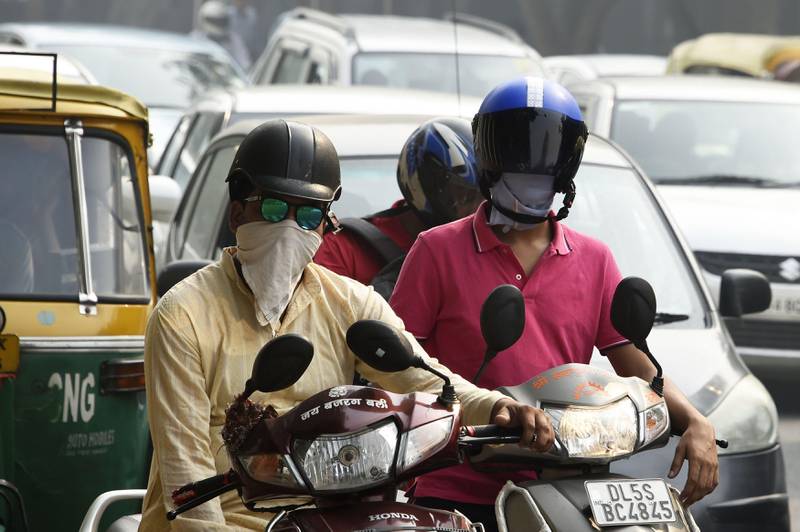 Indian bikers wearing face protection against air pollution on the road in heavy smog in New Delhi on October 20, 2017 the day after the Diwali Festival.
New Delhi was shrouded in a thick blanket of toxic smog a day after millions of Indians lit firecrackers to mark the Diwali Festival. / AFP PHOTO / DOMINIQUE FAGET
