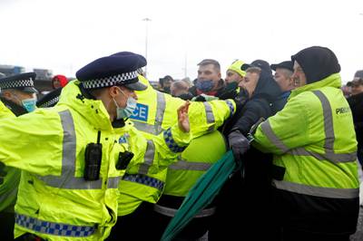 Police officers scuffle with drivers trying to stop trucks leaving the port and keep it closed until they are allowed to travel to Europe, at the Port of Dover, as EU countries impose a travel ban from the UK following the coronavirus disease (COVID-19) outbreak, in Dover, Britain, December 23, 2020. REUTERS/John Sibley