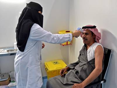A nurse checks the temperature of a man before administering a dose of Covid-19 vaccine at the Riyadh International Convention and Exhibition Centre in the Saudi Arabian capital.  AFP