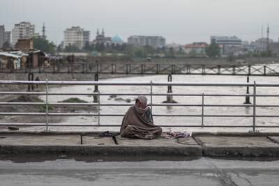 An Afghan man sits begging on the roadside