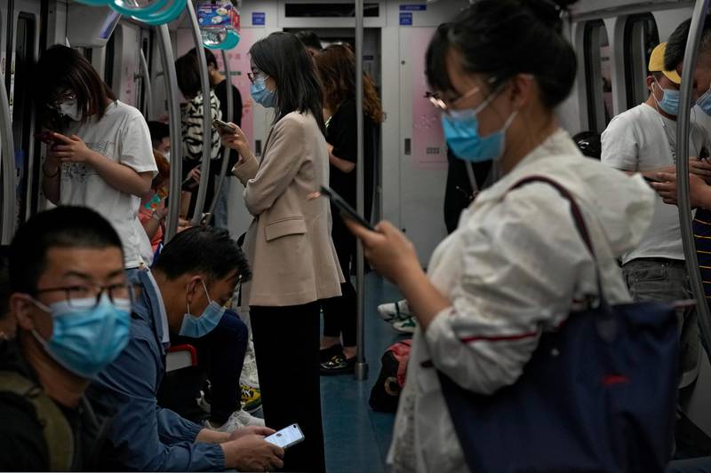 Commuters wearing face masks to help curb the spread of the coronavirus ride on a subway train in Beijing. AP Photo