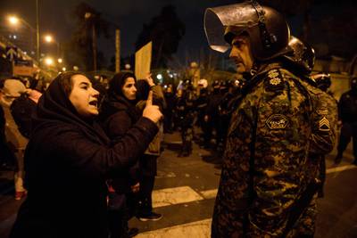 TOPSHOT - A woman attending a candlelight vigil, in memory of the victims of Ukraine International Airlines Boeing 737, talks to a policeman following the gathering in front of the Amirkabir University in the Iranian capital Tehran on January 11, 2020.  / AFP / ISNA / ISNA / Mona HOOBEHFEKR
