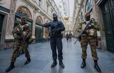 A police officer and soldiers on security duty inside Galerie de la Reine following the terror alert level being elevated to 4/4, in Brussels, Belgium, on November 22, 2015. Stephanie Lecocq/EPA