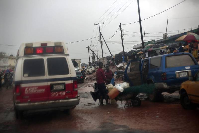 An ambulance speeds through traffic towards the clinic carrying six patients with signs of Ebola from the village of Freeman Reserve in Monrovia. Even when ambulances can reach people, the fear of being transported to a facility where more than half the patients leave in body bags keeps some from going.