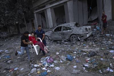 Palestinians amid the rubble following Israeli air strikes that razed a neighbourhood in Gaza city. AP