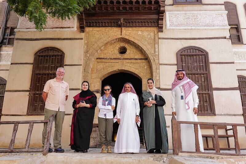 Alan Morrissey and Reem Philby with officials from the Saudi Ministry of Culture who greeted them in front of the historic Nassif House building in Jeddah