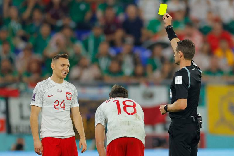 Poland midfielder Przemyslaw Frankowski is shown a yellow card by Australian referee Chris Beath. AFP