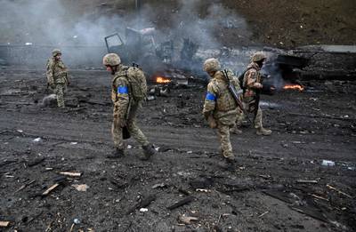 Ukrainian soldiers collect unexploded shells in the capital. AFP