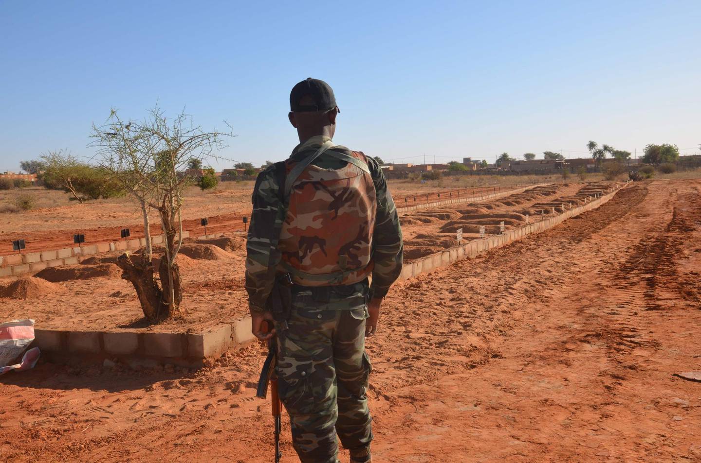 TOPSHOT - A Niger soldier looks at the graves of the soldiers killed before the arrival of the Leaders of the G5 Sahel nations in Niamey, on December 15, 2019. Leaders of the G5 Sahel nations paid homage at the graves of 71 Niger military personnel killed in a jihadist attack on December 10, 2019, ahead of a regional summit to coordinate a response to the growing unrest.
 / AFP / Boureima HAMA
