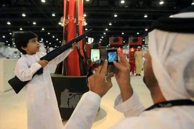 A small boy poses with a rifle at Adihex.
