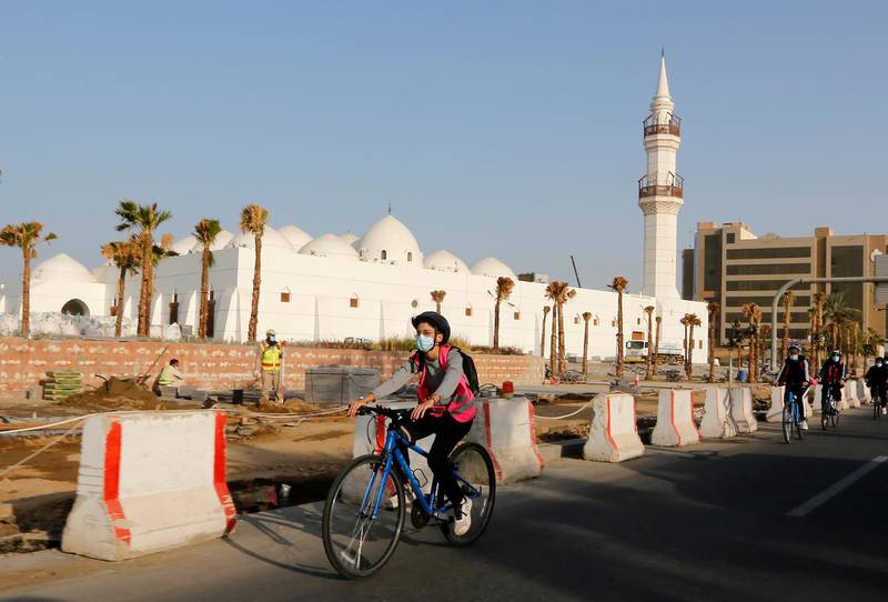 Members of the Brave women's cycling team ride past Al Jaffali mosque in Jeddah. AP