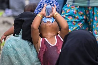 A child drinks after arriving by boat in Indonesia. Many Rohingya are fleeing refugee camps in Cox's Bazaar, Bangladesh, where kidnapping, rape and violence have become common. AFP
