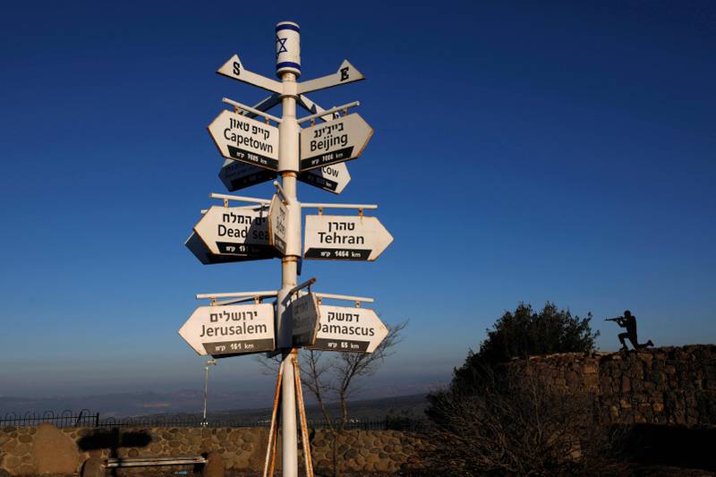 A metal cutout of an Israeli soldier stands behind signs pointing out distances to different cities at an army post on Mount Bentalin in the Israeli-annexed Golan Heights. AFP
