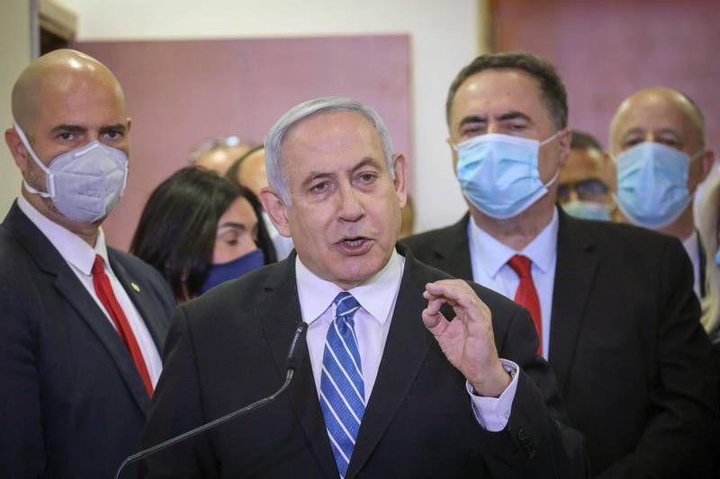 File - In this Sunday, May 24, 2020 file photo, Israeli Prime Minister Benjamin Netanyahu, accompanied by members of his Likud Party in masks, delivers a statement before entering the district court in Jerusalem. Netanyahu is on trial for accepting gifts from wealthy friends. But that has not stopped him from seeking another gift from a wealthy friend to pay for his multi-million-dollar legal defense. The awkward arrangement opens a window into the very ties with billionaire friends that plunged Netanyahu into legal trouble and sheds light on the intersection of money and Israeli politics. (AP Photo/Yonatan Sindel/Pool Photo via AP, File)