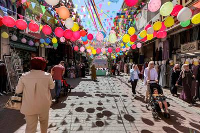 Palestinians walk along a decorated street in the old city of Nablus in the occupied West Bank. AFP
