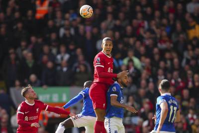 Liverpool's Virgil van Dijk, centre, heads the ball during the English Premier League soccer match between Liverpool and Everton. AP