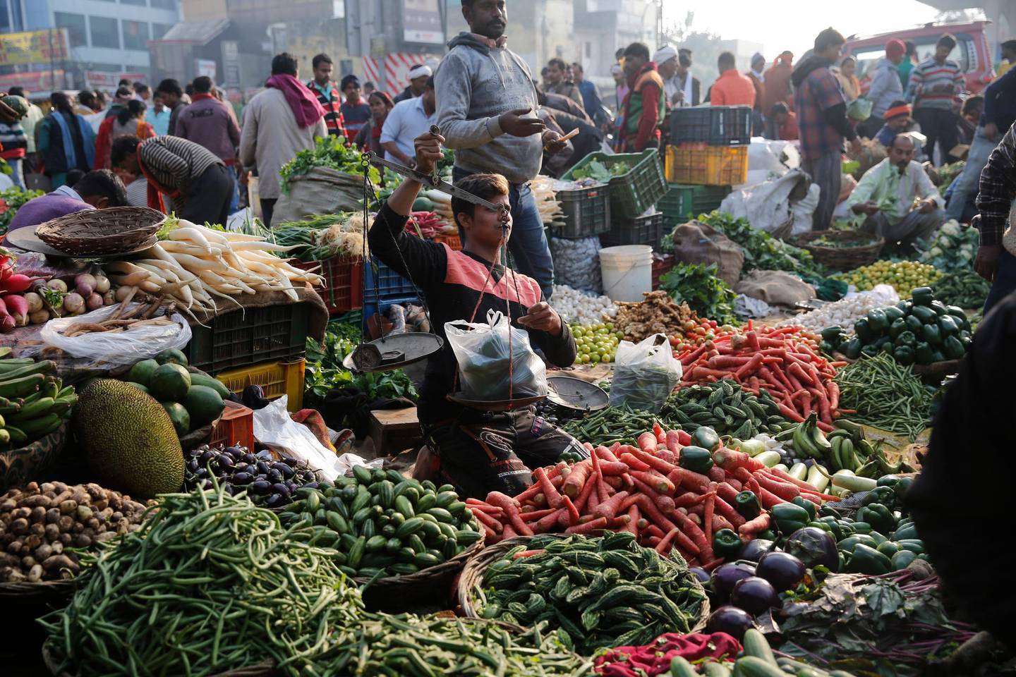 A vegetable vendor weighs vegetables at a market in Lucknow, India, Saturday, Nov. 30, 2019. Indiaâ€™s economic growth slipped to 4.5%, its slowest pace in six years, in the July-September quarter, with the labor-intensive manufacturing sector contracting.(AP Photo/Rajesh Kumar Singh)
