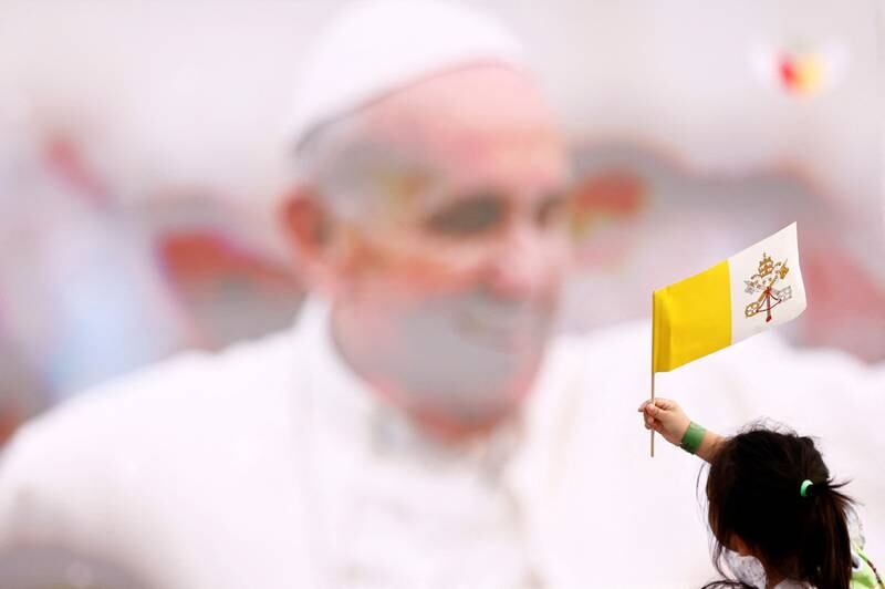 A child waves a Vatican City flag as people gather for Mass at Bahrain National Stadium during Pope Francis's visit in Riffa, Bahrain. Reuters