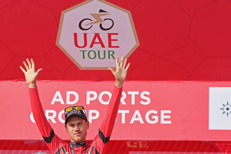 Lucas Plapp of Ineos Grenadiers celebrates on the podium after receiving the red jersey on the second stage of the UAE Tour. AFP
