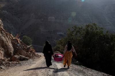 Carrying belongings outside the village of Tikht. Reuters