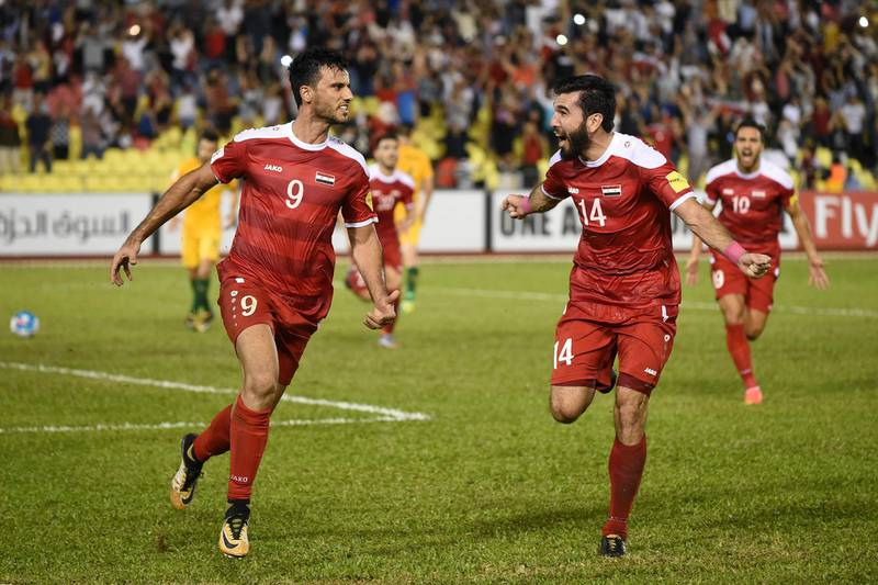 Omar Al Somah of Syria (L) celebrates a penalty goal with a teammate against Australia during the 2018 World Cup qualifying football match between Syria and Australia at the Hang Jebat Stadium in Malacca on October 5, 2017. / AFP PHOTO / MOHD RASFAN
