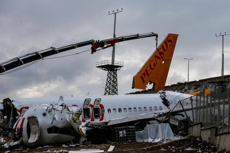 Workers remove the wreckage after investigators has finished their work at the Pegasus Airlines plane that skidded Wednesday off the runway at Istanbul's Sabiha Gokcen Airport, in Istanbul. AP Photo