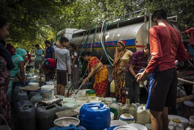 Residents of New Delhi fill containers with water from a municipal tanker. Bloomberg