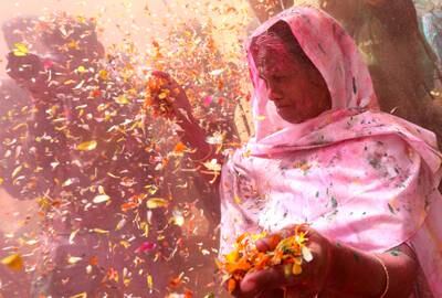An Indian widow throws flower petals while participating in Holi celebrations in Vrindavan, Uttar Pradesh. EPA