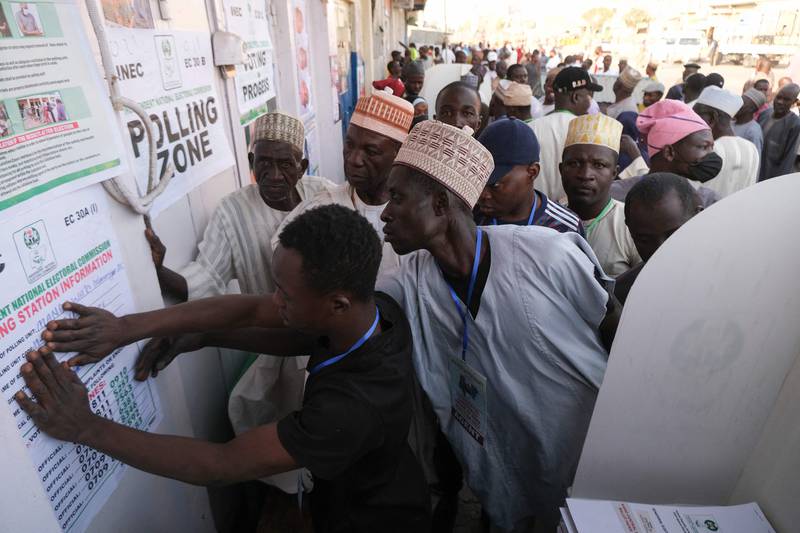Party agents look at polling station information in Kano.  AFP