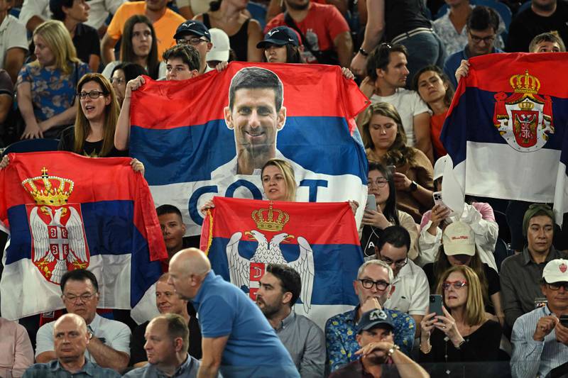 Supporters of Novak Djokovic hold flags of Serbia with his image in the stands. AFP
