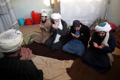 FILE- In this Dec. 14, 2019, file photo, jailed Taliban pray inside the Pul-e-Charkhi jail after an interview with The Associated Press in Kabul, Afghanistan. After a series of delays, Afghan President Ashraf Ghani issued a decree early Wednesday, March 11, 2020,  promising to release 1,500 Taliban prisoners as a goodwill gesture to get intra-Afghan negotiations started, even though a deal signed by the United States and the Taliban calls for the release of up to 5,000 prisoners ahead of the much sought after negotiations. (AP Photo/Rahmat Gul, File)