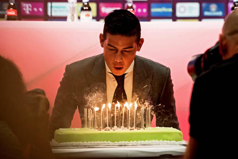 epa06083108 Bayern Munich's new player James Rodriguez blowas out candles on his birthday cake as he is presented during a press conference in Munich, Germany, 12 July 2017. German Bundesliga soccer club Bayern Munich announced on 11 July 2017 James Rodriguez comes from Spain's Real Madrid on a two-year loan.  EPA/LUKAS BARTH