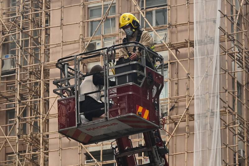 A firefighter rescues a person from a blaze at Hong Kong's World Trade Centre high-rise in the city's Causeway Bay district. AFP