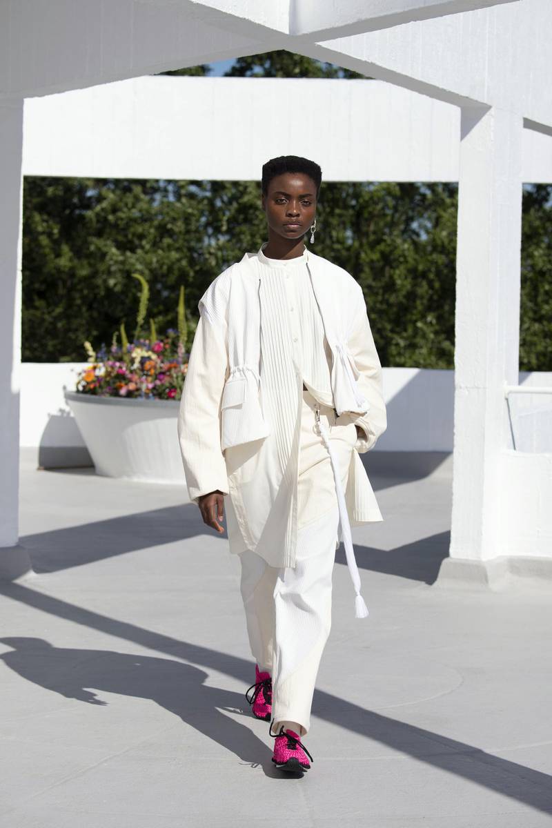 An all-white look with a shirt covered in small, precise pleats. Courtesy Qasimi