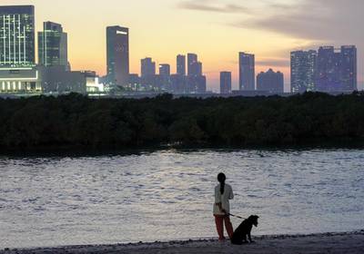 Abu Dhabi, United Arab Emirates, October 17, 2019.  Reem Festival.-- Standalone:  A woman and her dog enjoy the sunset at Al Reem Island.Victor Besa/The NationalSection:  NAReporter:  Panna Munyal