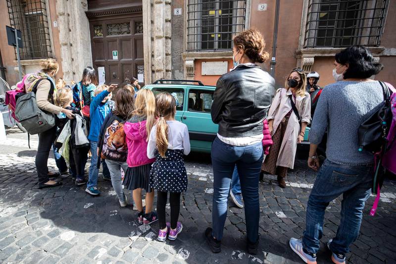 Students exit the Gianturco primary school in Rome. A cabinet meeting on Monday was set to make wearing face masks outdoors compulsory across Italy. Lazio, the region around Rome, has already taken the measure, at the weekend. EPA