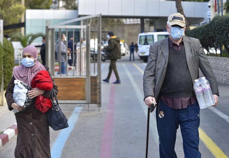 People wearing wearing protective masks walk out of the El-Kettar hospital in the Algerian capital Algiers. AFP